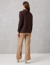 Buzo de tejido acanalado color blanco, con cuello alto y diseño de patrón en V en el frente. Presenta un corte holgado con mangas integradas sin costura de sisa.