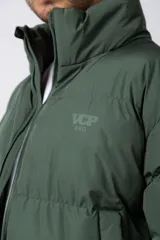 Campera puffer de corte relajado en color verde oscuro, con cuello alto, cierre frontal completo y logo bordado en el pecho.