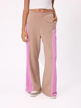 Babucha de corte holgado en color beige con paneles laterales en color fucsia y vivos blancos. Presenta cintura elástica y logo bordado en la parte superior.