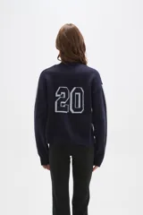 Sweater de tejido jacquard color azul marino, con cuello redondo y diseño holgado. Presenta franjas laterales en color gris claro a lo largo de las mangas largas.