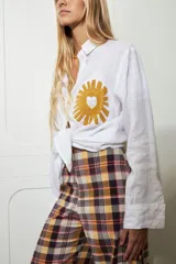 Camisa blanca de lino con bordado de pulpo azul en el pecho, de corte recto y manga larga.