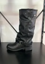 Botas de caña alta negras con hebilla decorativa y suela con leve taco.