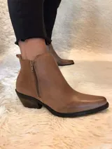 Botín negro de cuero con punta fina y taco de bloque. Tiene cierre lateral y caña baja.