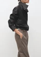 Pantalón de tiro medio color marrón con sutil diseño de raya diplomática, de corte entallado y diseño crop. Cuenta con bolsillos laterales, trabillas y cierre frontal con cremallera, botón y ganchos ocultos.