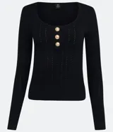 Blusa negra de punto con escote en U, mangas largas y detalle de tres botones dorados.