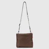 Cartera tipo bandolera de diseño minimalista, color bordó, con correa ajustable y desmontable. Presenta el logo de la marca grabado en el frente y una etiqueta lateral distintiva.