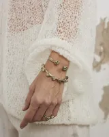 Pulsera esclava abierta de diseño artesanal con acabado orgánico y texturizado, realizada en bronce.