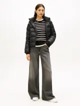 Campera térmica de plumón Tommy Hilfiger, color negro, confeccionada en nailon ligero con acabado repelente al agua. Presenta capucha fija, cuello levantado, cierre frontal de cremallera y puños tejidos acanalados.