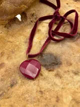 Gargantilla con cinta de terciopelo color beige y dije de nácar con forma de corazón.