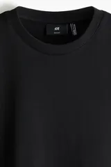 Remera negra de corte estándar y diseño clásico, con cuello redondo y mangas cortas. Confeccionada con fibra COOLMAX que transporta el sudor a la superficie.