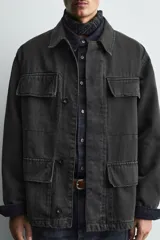 Chaqueta de corte relajado confeccionada en tejido de mezcla de algodón y lyocell con efecto lavado. Presenta cuello solapa, manga larga, cierre frontal con botonadura oculta por solapa y cuatro bolsillos frontales con solapa.
