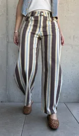 Jean modelo barrel de corte amplio, con diseño de rayas verticales en tonos marrón chocolate, celeste, tostado y blanco.