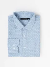 Camisa de manga larga con estampado de puntos finos en color azul sobre fondo blanco, cuello clásico y cierre frontal con botones.