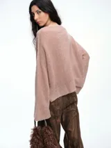 Sweater de punto negro con lentejuelas sutiles, de corte holgado, hombros caídos y mangas largas con terminación acampanada.