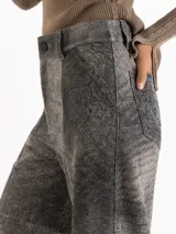 Pantalon de cuero ovino gris con diseño de pata ancha y recortes geométricos a la altura de las rodillas.