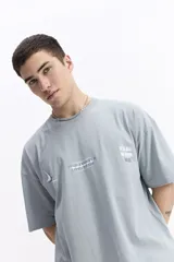 Remera de manga corta y escote redondo, color celeste, con estampado frontal que incluye las frases "Your anxiety is lying to you" y "It's all in your head", junto a un diseño abstracto.