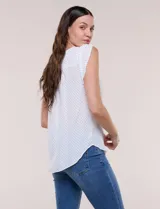 Blusa de gasa blanca con estampa de lunares negros, escote en V con botones frontales y mangas cortas casquillo con abertura.