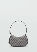 Bolso de hombro tipo baguette con diseño pequeño y estructurado. Presenta un estampado de monograma en tonos gris y negro, con detalles en contraste y cierre de cremallera superior. Incluye un asa corta ajustable.