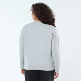 Sweater de punto gris con cuello en V, mangas largas y puños acanalados.
