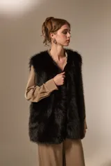 Chaleco sin mangas de piel sintética en color negro, con diseño abierto y corte recto.