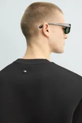 Sudadera de manga corta con corte relajado, confeccionada en tejido técnico compacto de algodón con elasticidad. Presenta cuello redondo y detalle de tacha metálica en la espalda.