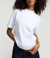 Blusa básica de algodón color celeste, con cuello alto y mangas cortas holgadas.