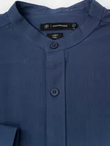 Camisa de manga larga Cuatroases color azul, confeccionada en algodón con textura tipo lino, cuello mao y cierre frontal de botones.