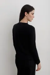 Remera de manga larga con efecto lavado, cuello redondo y estampa frontal con diseño de estrella y texto.
