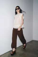 Blusa blanca sin mangas confeccionada en hilatura con viscosa y algodón. Tiene cuello redondo, detalle de bordados a contraste y cierre en espalda con abertura y botón.