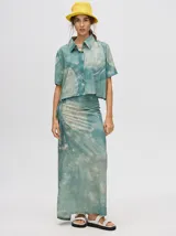 Falda midi tipo pareo color verde con estampado estilo tie-dye en tonos azul, naranja y blanco, con tiras ajustables en la cintura.