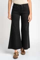 Jean de corte wide leg y tiro medio, confeccionado en algodón peinado de color negro. Presenta un diseño de pierna ancha con ruedo deshilachado y cierre frontal con botón y cremallera.