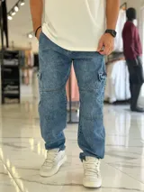 Pantalón cargo de jean azul con múltiples bolsillos en los laterales y diseño holgado.