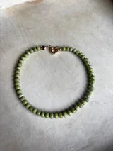 Collar de piedras naturales de calcedonia pulida en tonos verdes y granates, con detalle central de cristal de Murano y cierre tipo marinero con baño de oro 18k.