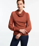 Blusa de punto color ladrillo con cuello alto boba, mangas largas con puños ajustados y detalle de hilo metalizado.