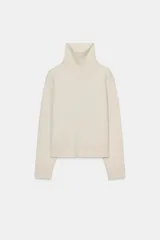 Jersey de punto liso confeccionado con lana, con cuello subido, manga larga y acabados en rib.