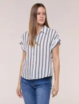 Camisa de calce holgado color blanco con rayas verticales negras, cuello camisero clásico, abotonadura frontal y mangas cortas.