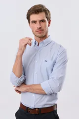 Camisa de manga larga con estampa de cuadros pequeños en tonos celeste y blanco, cuello con botones y bolsillo ojal en el pecho con detalle bordado.