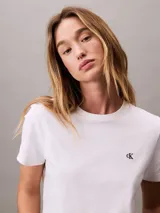 Remera de algodón regenerativo con cuello redondo y mangas cortas. Presenta un diseño clásico de corte regular con el logo de Calvin Klein bordado en pequeño en el pecho.