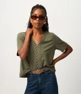 Blusa verde militar de piqué, corte slim, con escote en V y detalle texturizado en la vista delantera. Tiene mangas cortas.