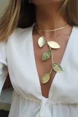 Collar rígido de bronce dorado con forma de hojas texturizadas.