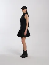 Top negro de lycra con escote halter, silueta entallada al cuerpo con ballenas, forrado con tejido tipo remería y espalda semi descubierta con cierres a la vista.