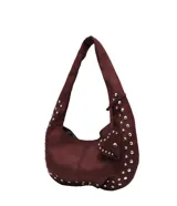 Cartera estilo hobo de gamuza color bordó, con diseño de asa única y detalle de dije en forma de corazón. Presenta aplicaciones de tachas metálicas plateadas a lo largo de los bordes y el asa.