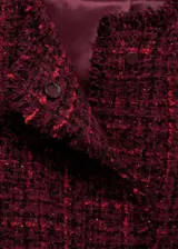 Chaqueta de corte recto y diseño corto confeccionada en tejido tweed jaspeado color bordó. Presenta cuello redondo, cierre frontal con botones, manga larga y dos bolsillos de ribete delanteros con terminaciones deshilachadas.