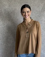 Remera color tostado de manga larga, con cuello polo y botones frontales.