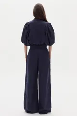 Pantalón sastrero de lino color azul marino, de corte wide leg, tiro alto con pinzas en la parte delantera y bolsillos laterales.