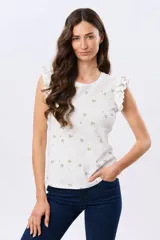 Remera blanca de algodón con estampado de ramas y pequeños frutos, escote redondo y mangas cortas con volados.