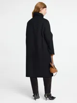 Tapado de paño color beige con chaleco desmontable de piel sintética.