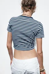 Camiseta cropped color amarillo, de corte slim fit, cuello redondo y manga corta.