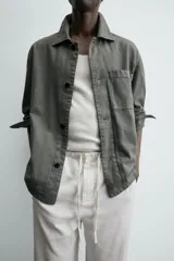 Sobrecamisa de hombre, color verde militar, con cuello solapa, manga larga y cierre frontal de botonadura. Presenta un bolsillo de plastrón en el pecho y bolsillos laterales en la cadera. El tejido tiene un efecto lavado.