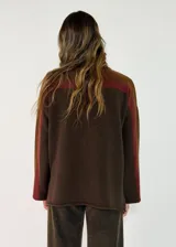 Sweater de punto con diseño color block en tonos gris oscuro, negro y gris claro. Presenta cuello alto, mangas largas y un corte holgado.